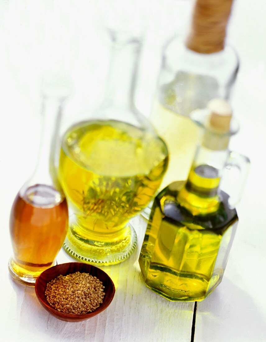 Assorted Types of Oil with a Bowl of Seeds