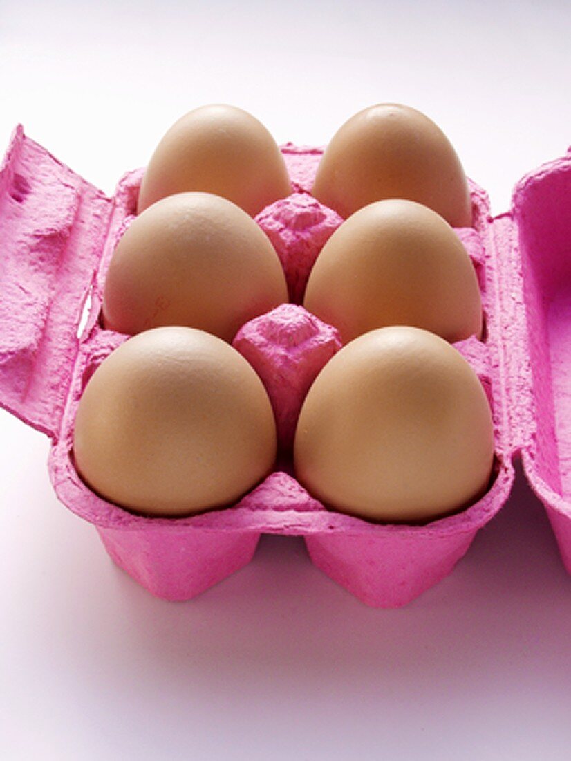 Braune Eier im rosa Eierkarton