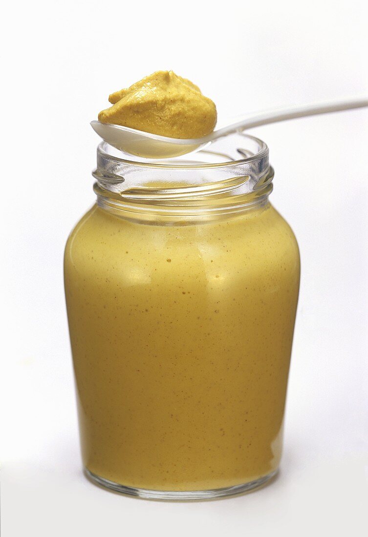 A Jar of Yellow Mustard with Spoonful