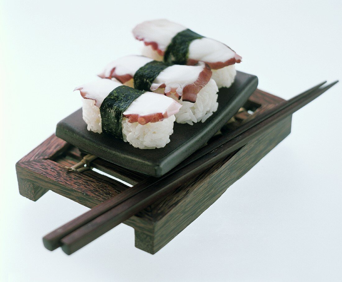 Drei Sushi mit Oktopus auf Sushibrett