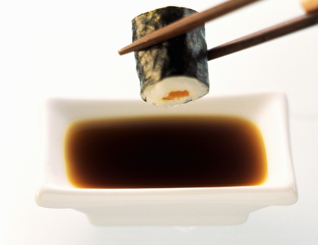 A Piece of Sushi Being Dipped
