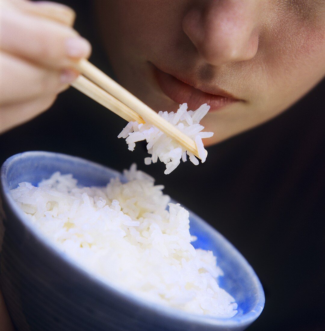 A Person Eating Rice with Chopsticks