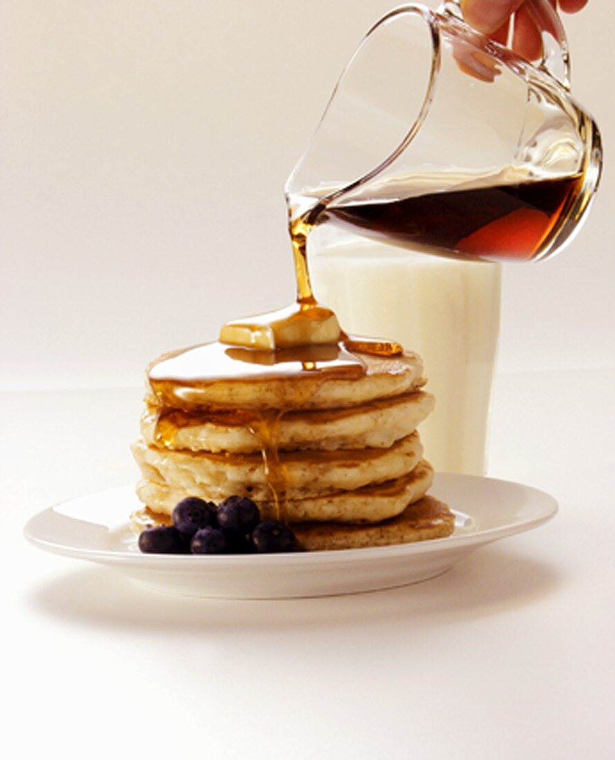 Pouring Maple Syrup Over A Stack Of License Images Stockfood