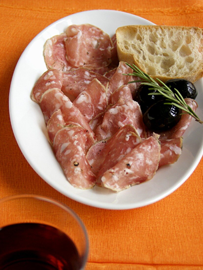 Mailänder Salami mit schwarzen Oliven und Weißbrot