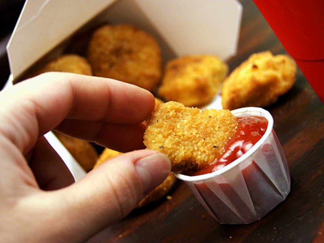 Dipping Chicken Nugget into Ketchup