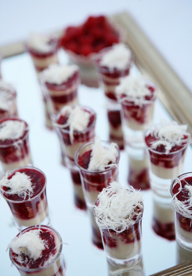 Small raspberry trifles with spun sugar in schnapps glasses