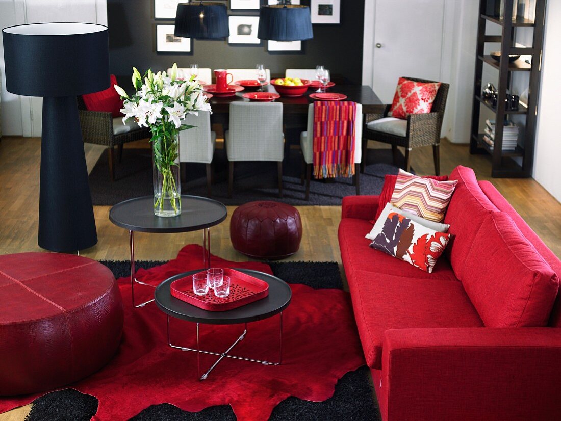 Living room with red couch, dining area in background