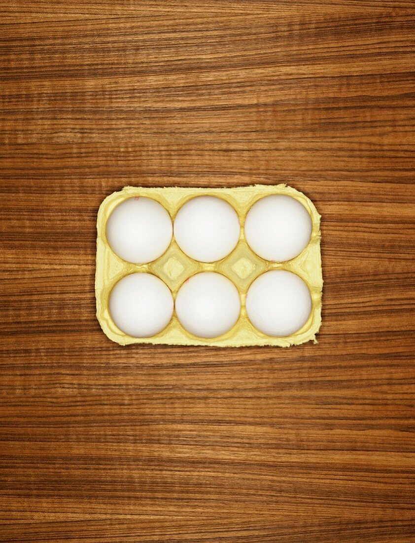 Sechs weiße Eier in einem Eierkarton