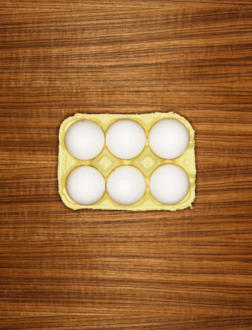 Six white eggs in an egg box