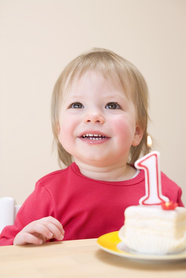 Small girl with a first birthday cake
