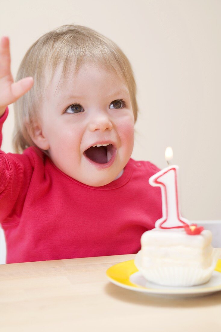 Kleines Mädchen mit Törtchen zum ersten Geburtstag