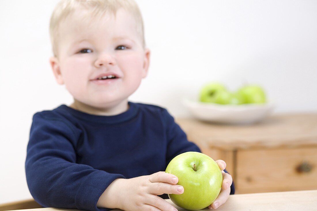 Small boy with a Granny Smith apple