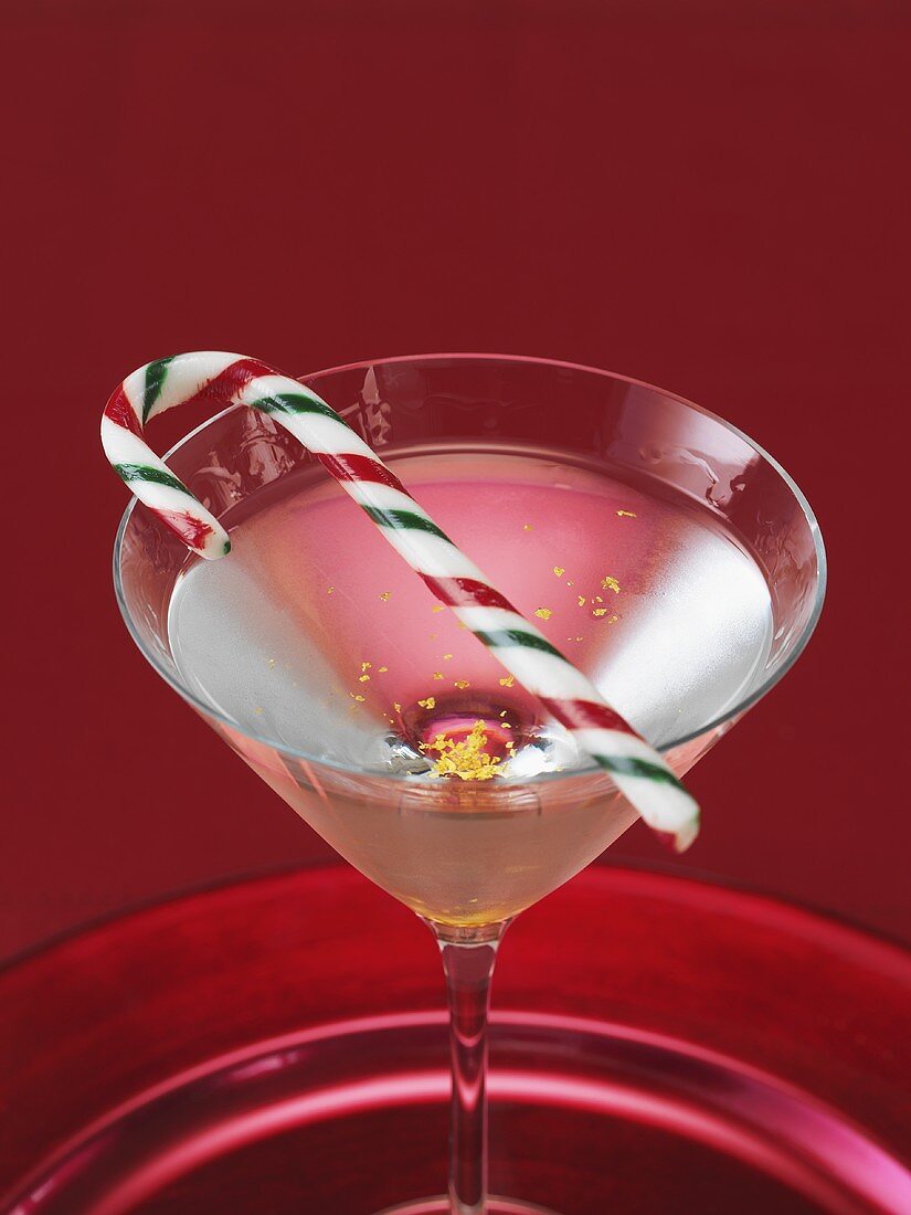 Martini garnished with gold leaf and candy cane