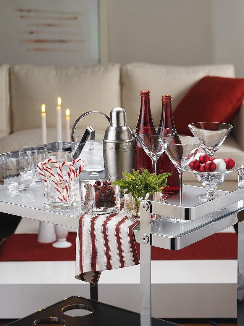 Bar utensils, candy canes and candles on serving trolley