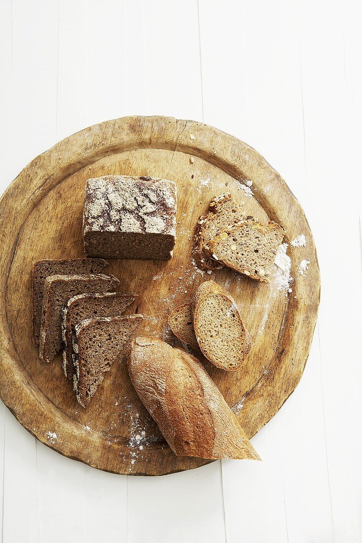 Various types of bread on wooden breadboard