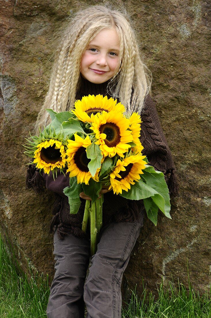 Blondes Mädchen mit Sonnenblumen