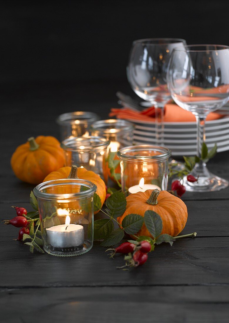 Pumpkins, rose hips, plates, tealights and wine glasses
