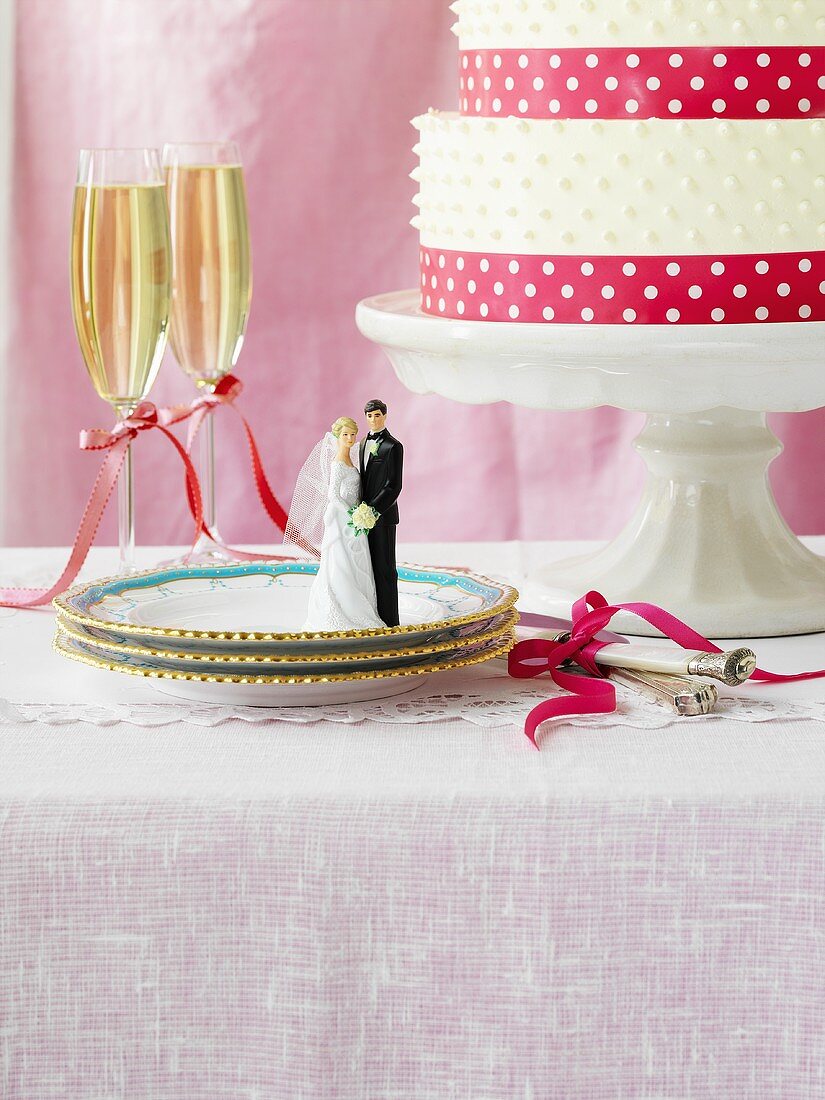 Wedding cake, two glasses of champagne, bride & groom toppers