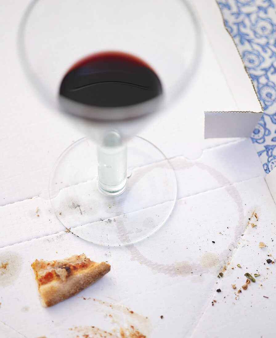 Remains of pizza and red wine on pizza box