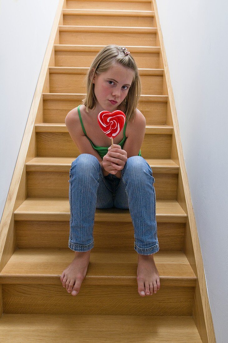 Girl with lollipop sitting on the stairs