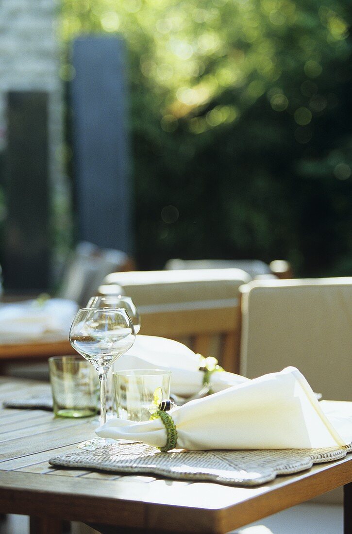 Tisch mit Serviette und Weingläsern im Freien