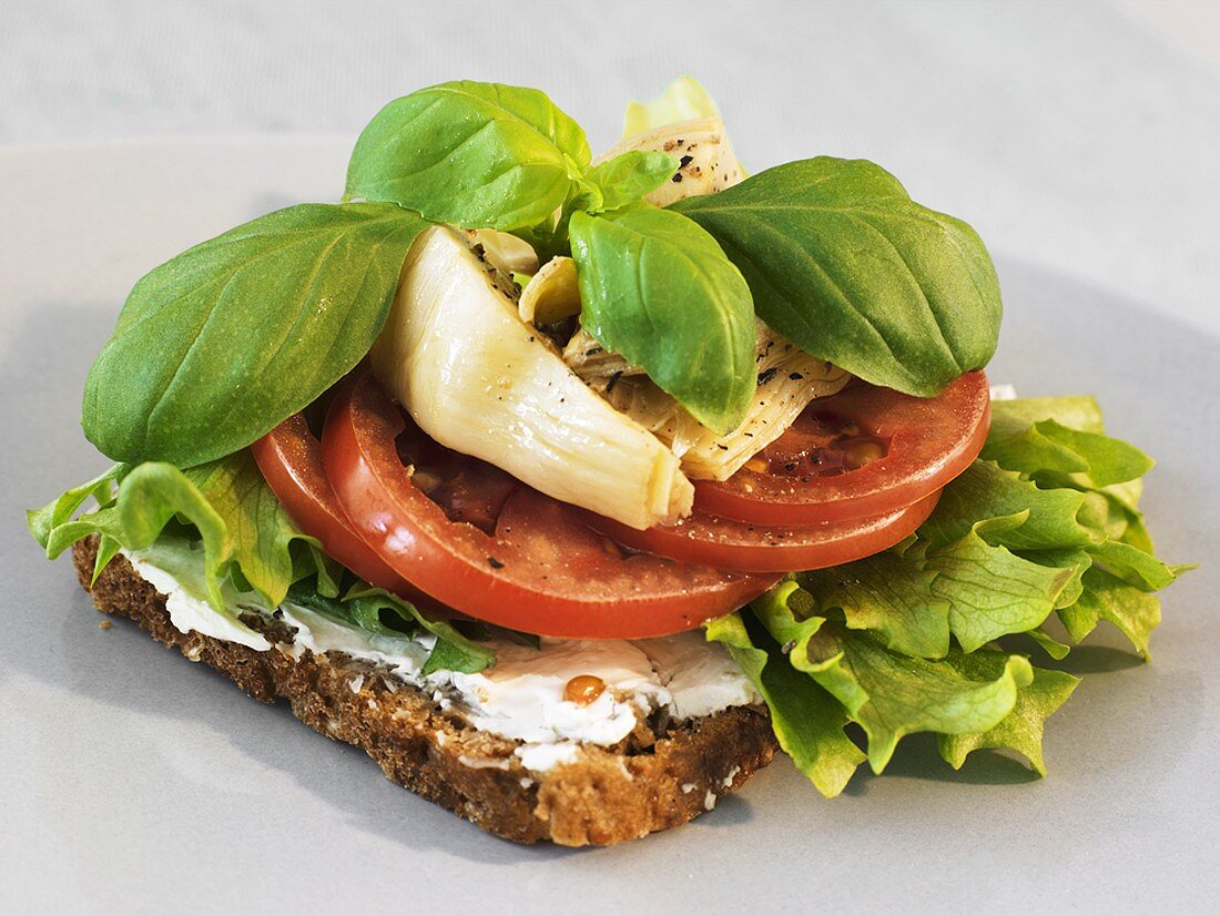 Whole-grain bread topped with soft cheese, tomatoes & artichokes