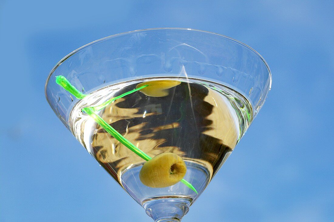 Martini mit Olive vor blauem Himmel