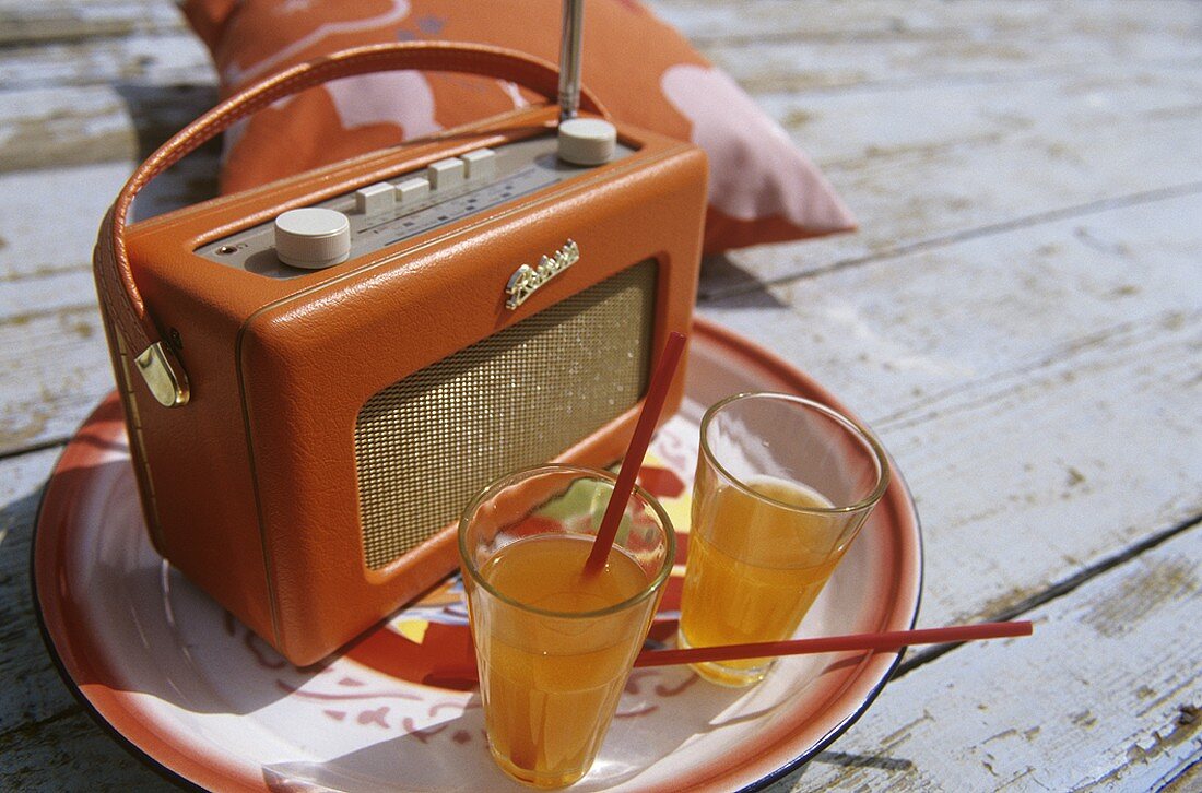 Picnic scene: glasses of juice & old radio on wooden planking