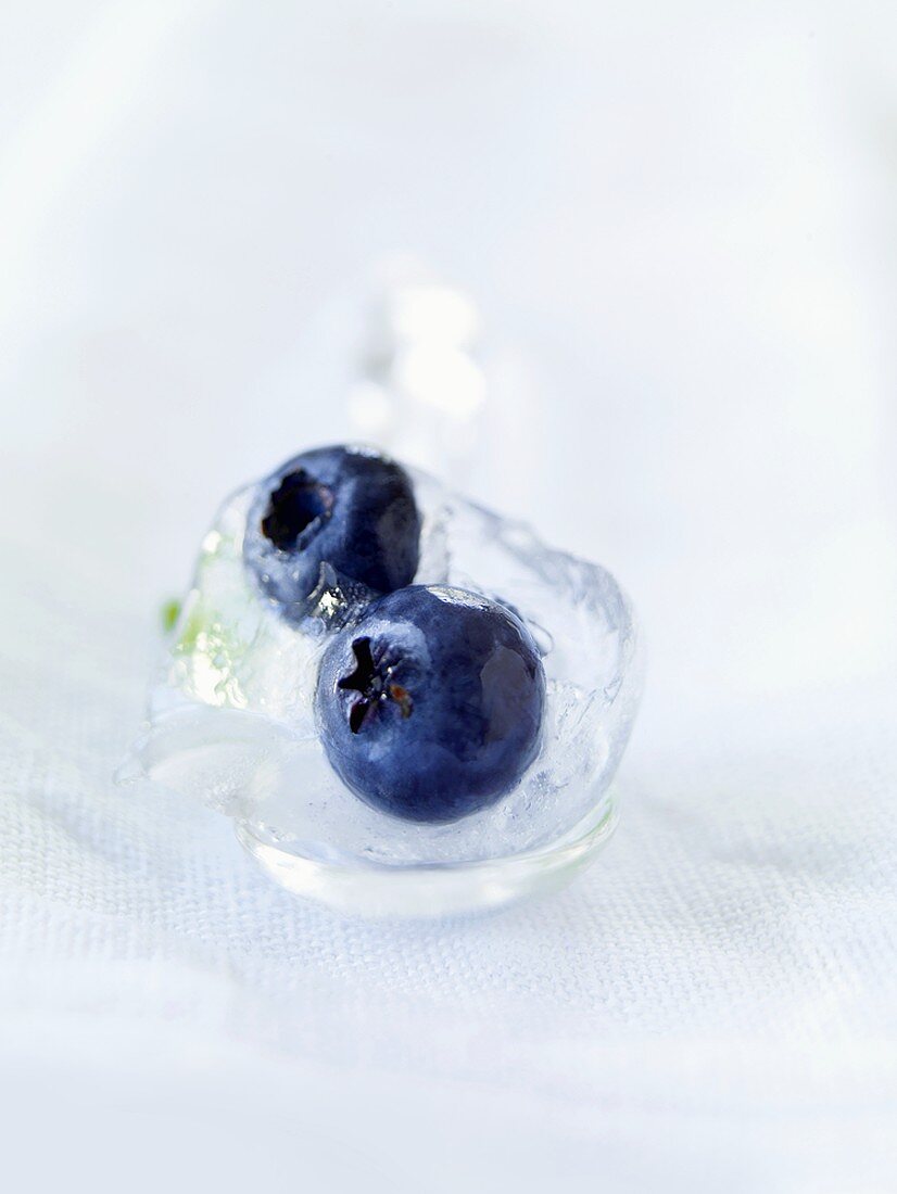 Two blueberries in an ice cube