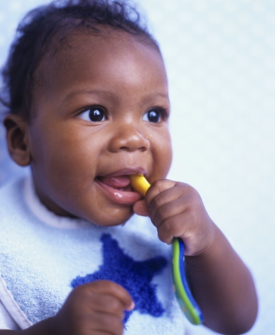 Baby chewing a plastic spoon