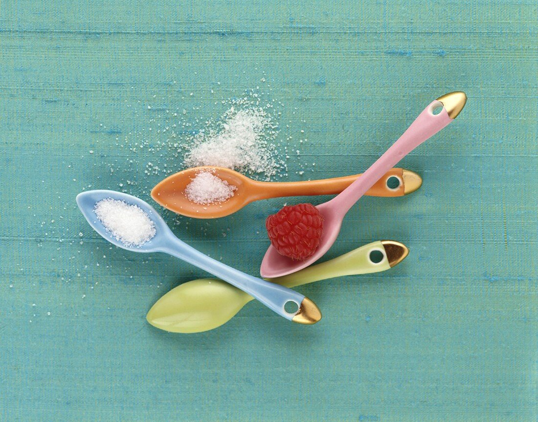 Sugar and raspberry in dessert spoons