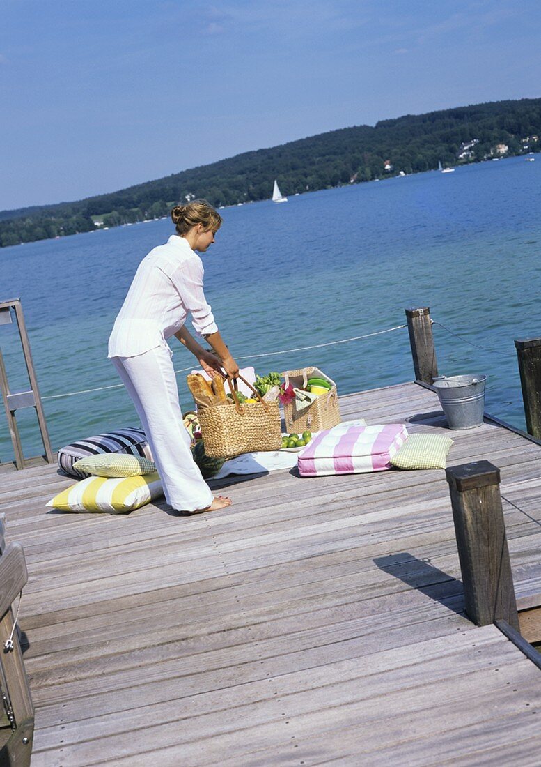 Frau mit einer Picknicktasche am Seeufer