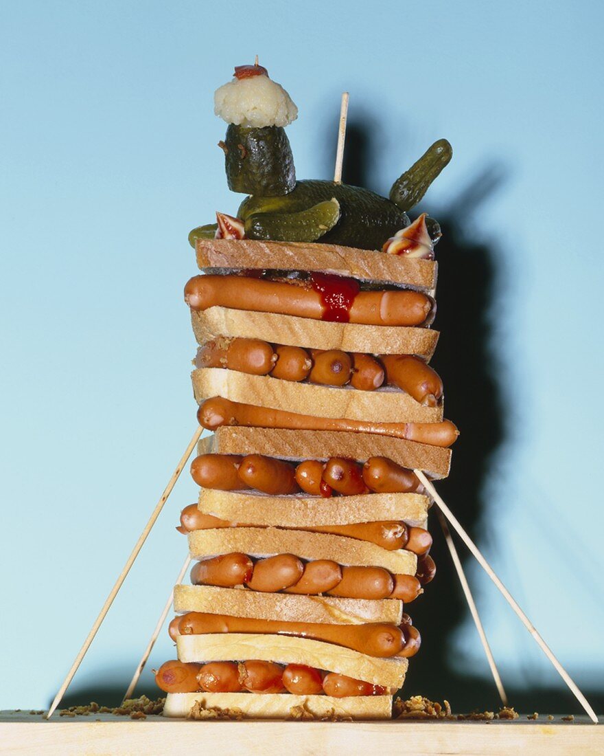 A tower of sausages and slices of white bread