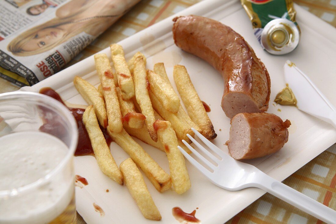 Sausage and chips on paper plate