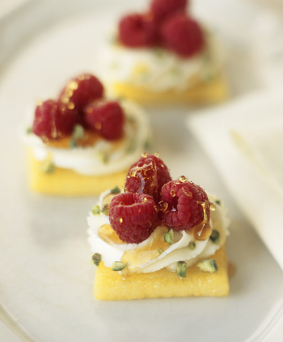 Sweet polenta slices topped with raspberries & pistachios