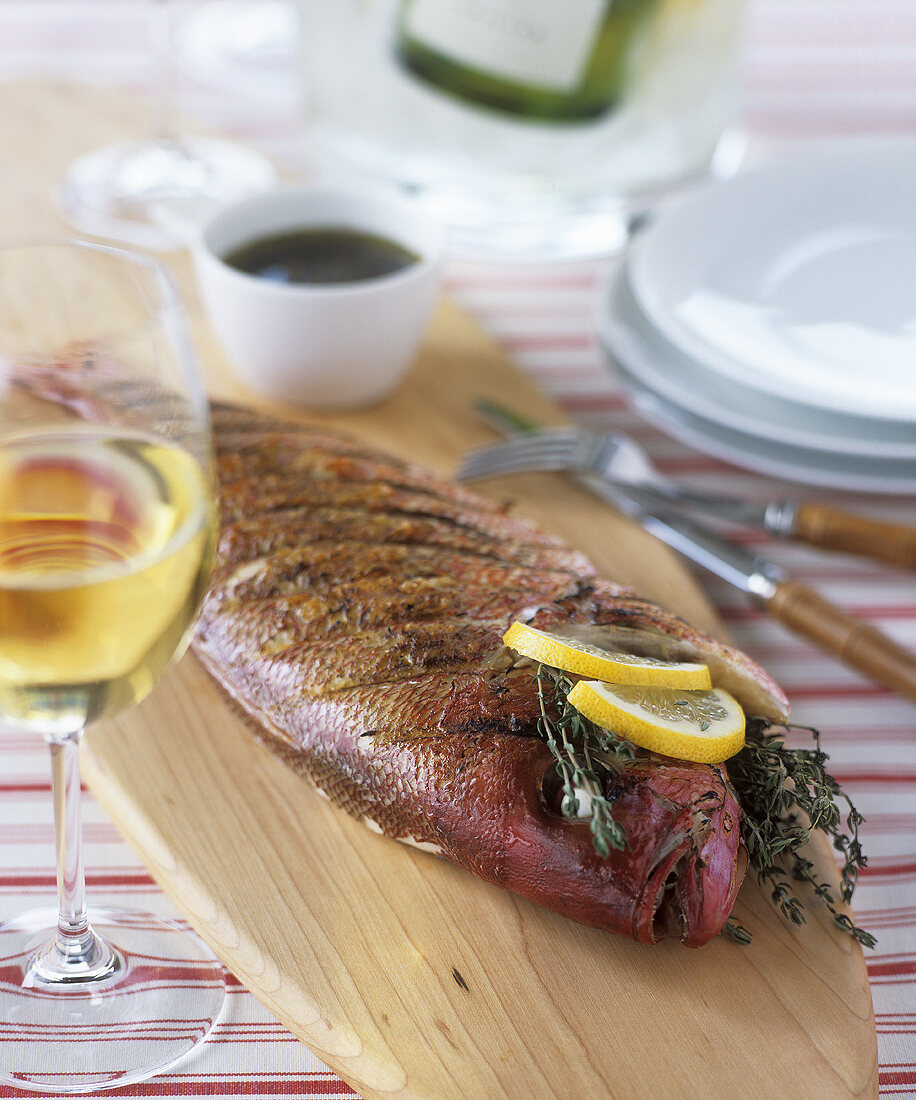 Grilled bream with lemon and thyme on a wooden board