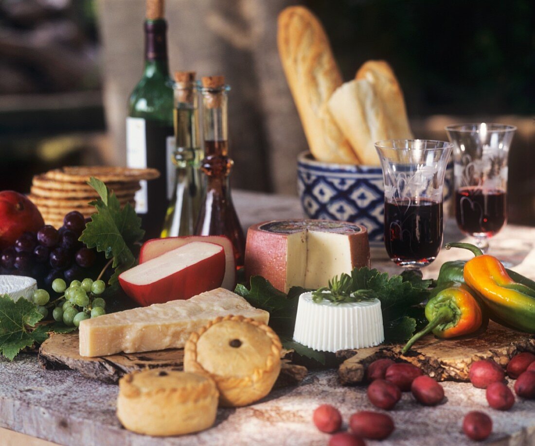 Stillleben mit Empanadas, verschiedenem Käse, Brot und Wein