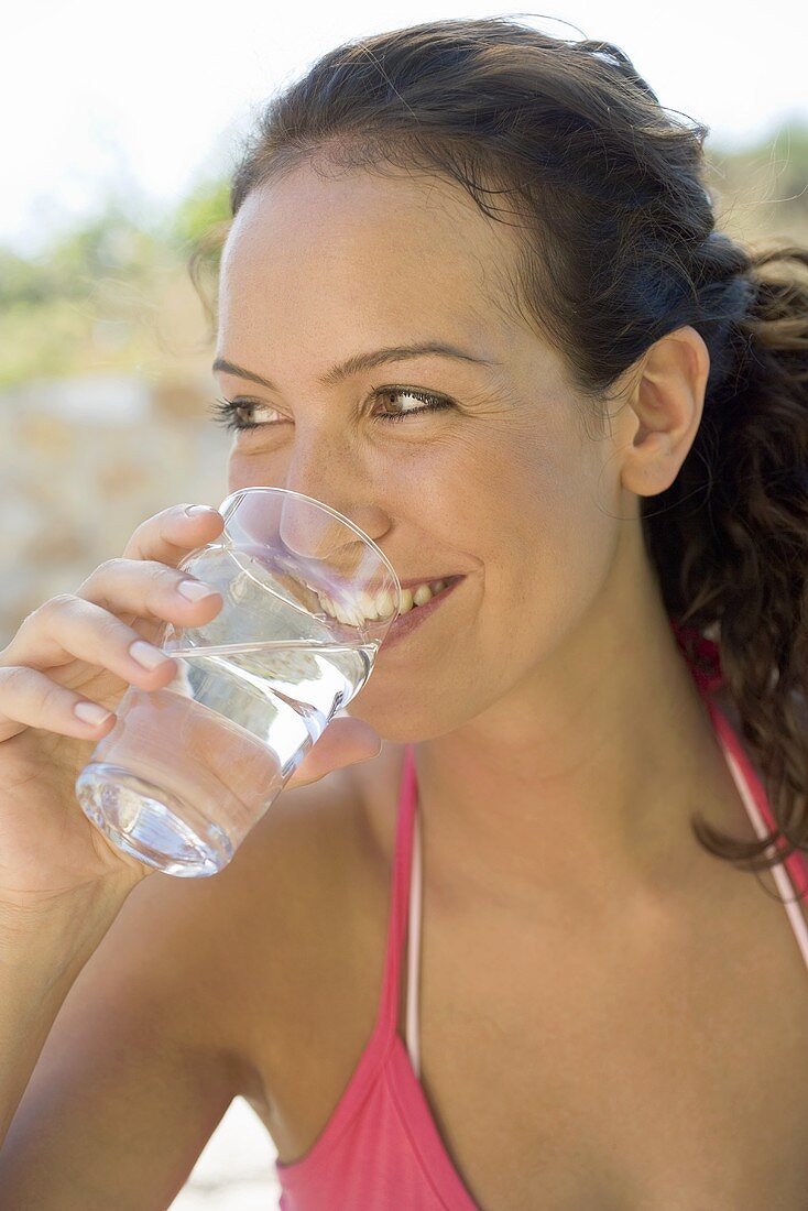 Frau trinkt ein Glas Mineralwasser