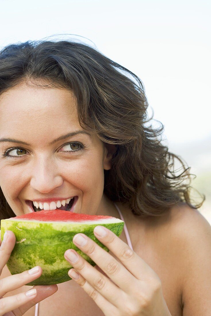 Woman eating a piece of watermelon