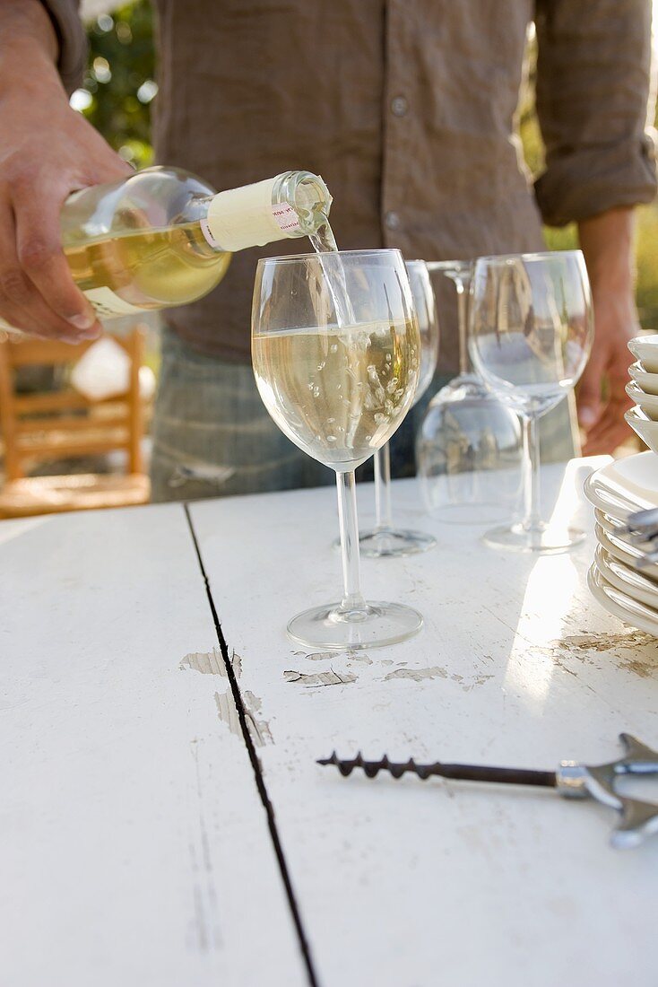 Man pouring white wine