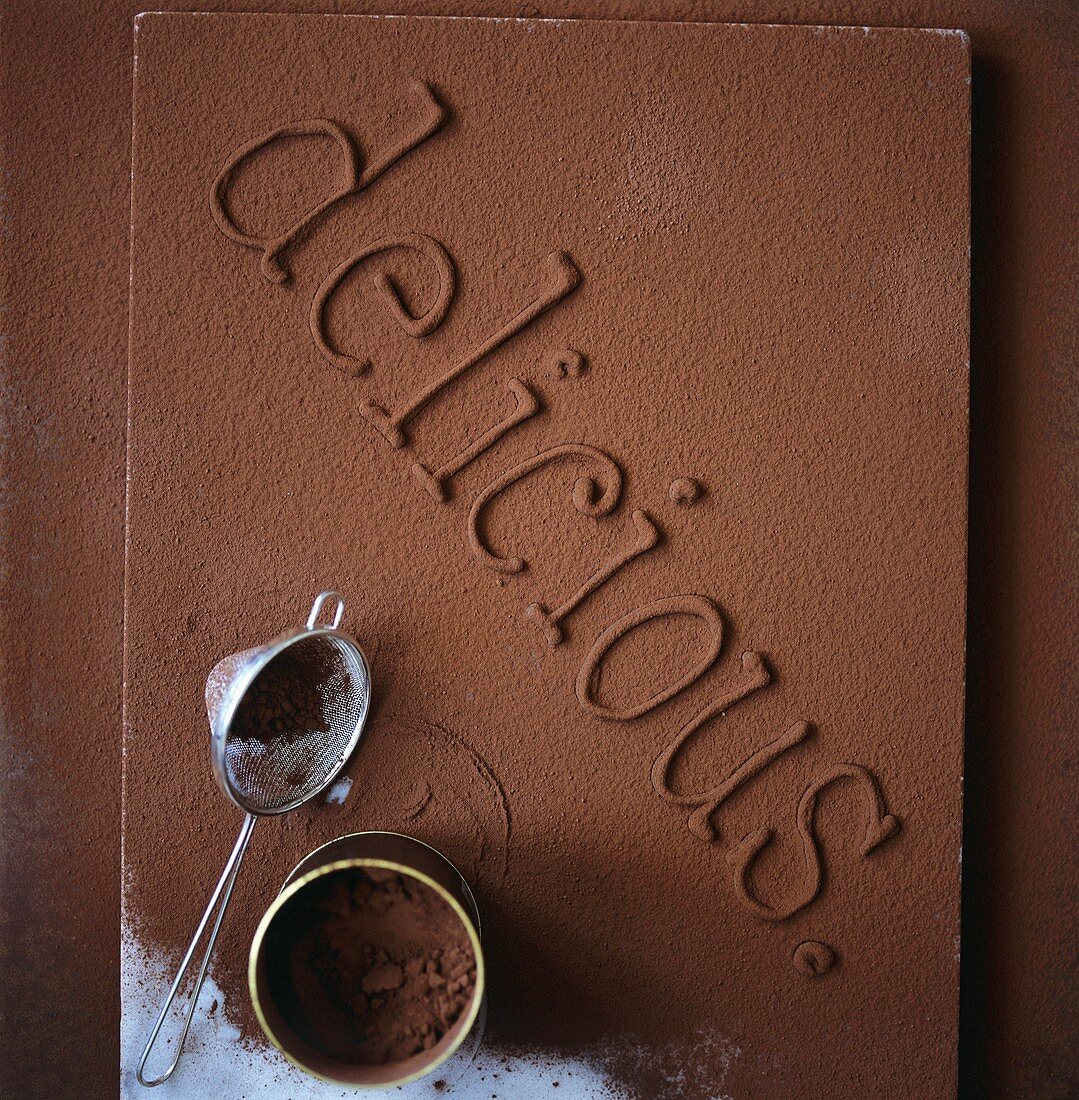 Schokoladenschrift 'delicious' mit Kakaopulver bestäubt