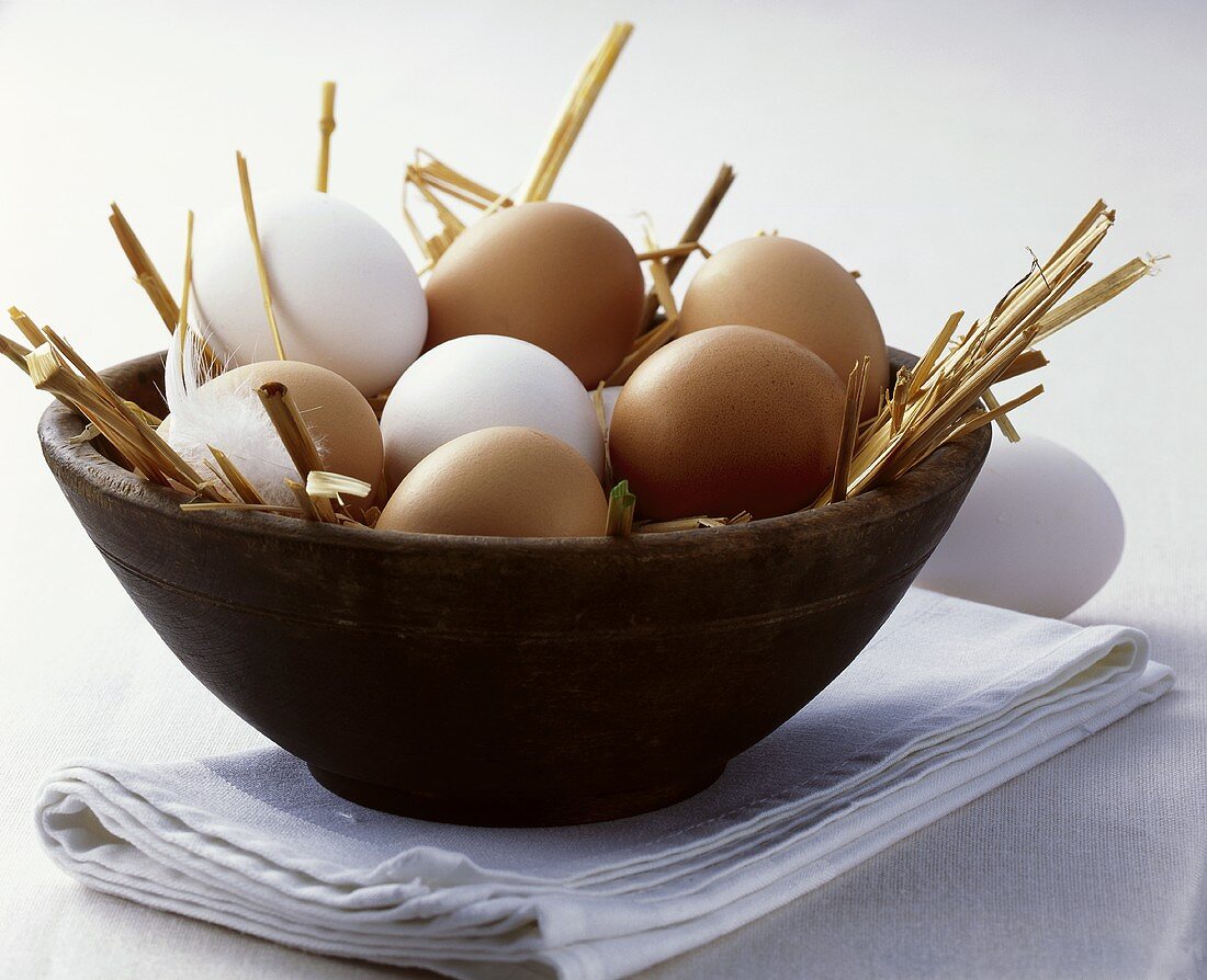 Brown and white eggs in a wooden bowl