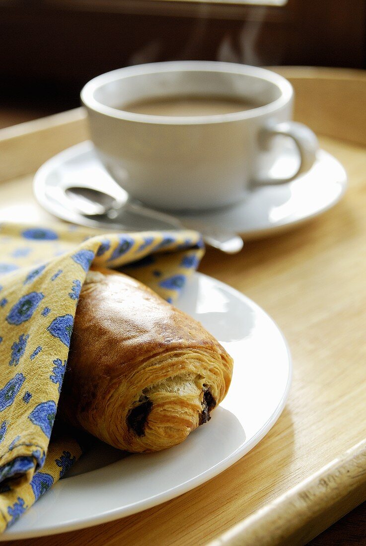 Ein Schokocroissant mit Kaffee