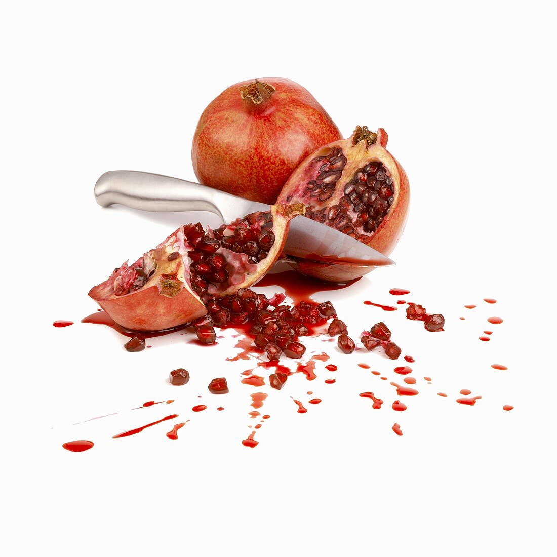 Whole pomegranate and pomegranate, cut open with knife
