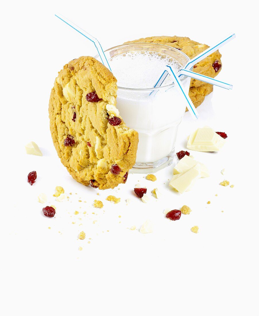 A glass of milk with chocolate chip and cranberry biscuits