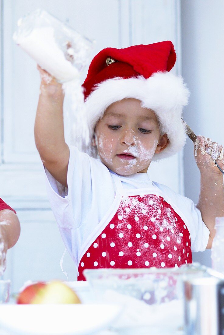 Small boy tipping flour into a bowl