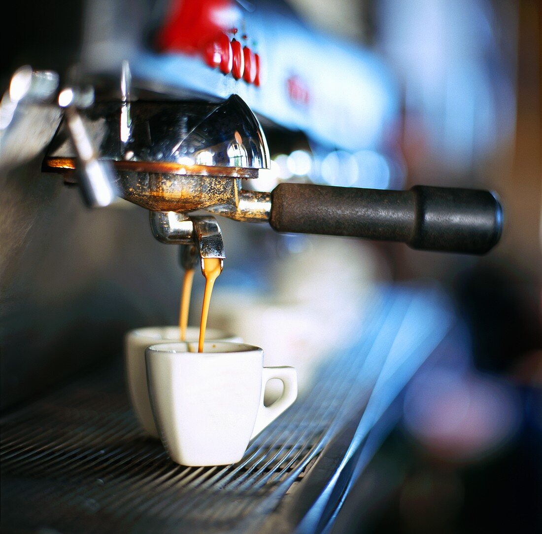 Espresso fliesst aus der Maschine in zwei Tassen