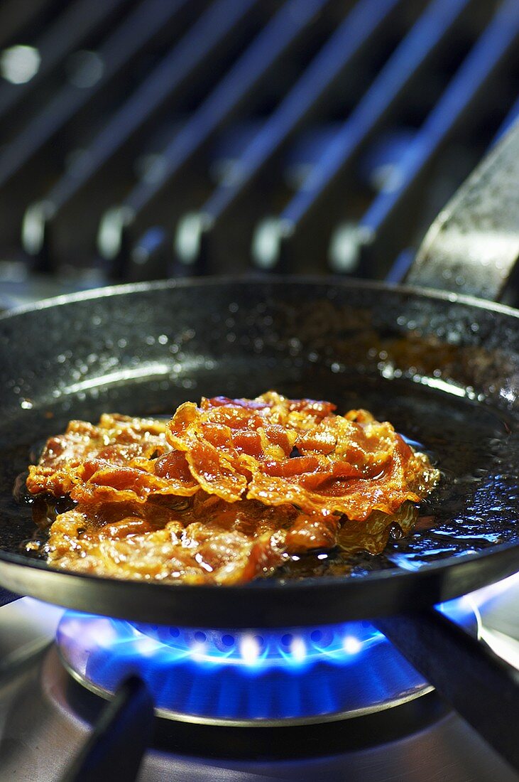 Crispy bacon in frying pan