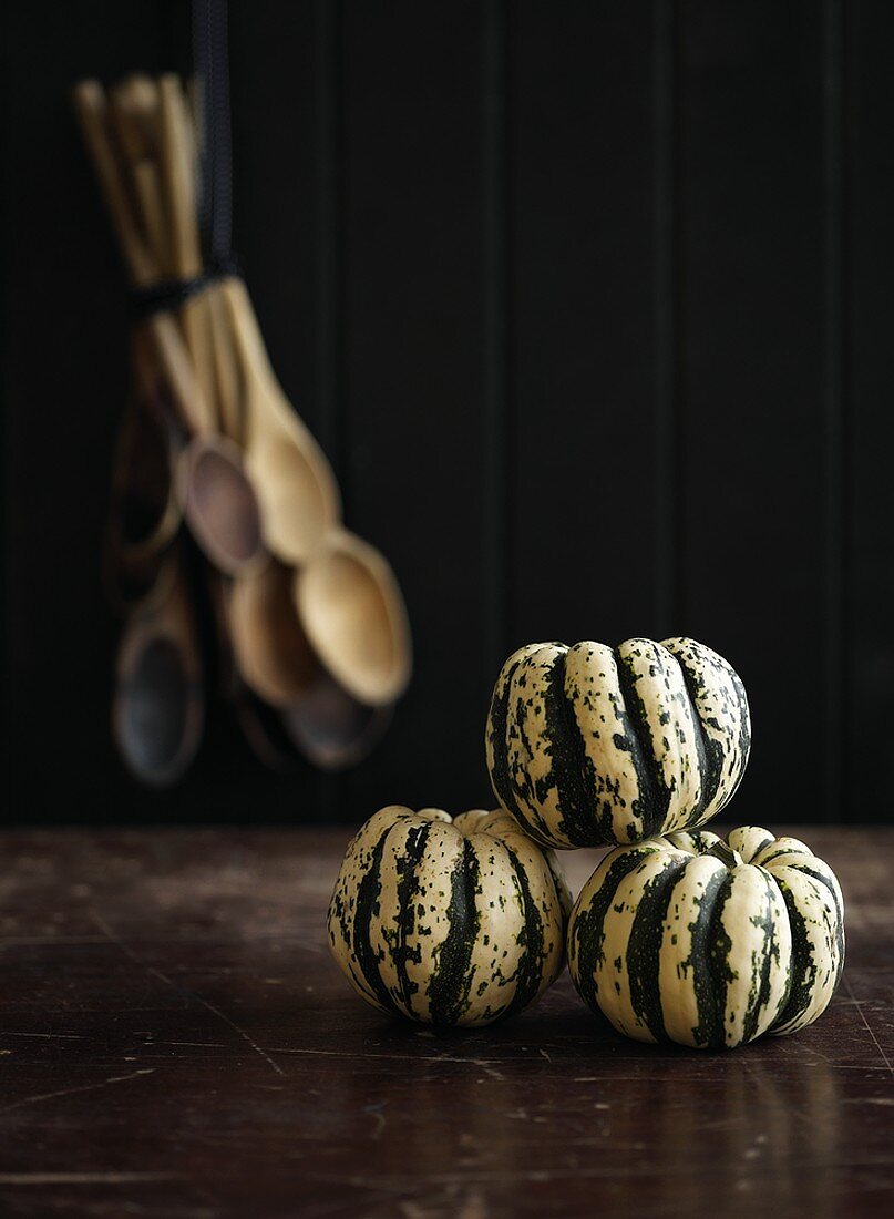 Three ornamental gourds with wooden spoons in background