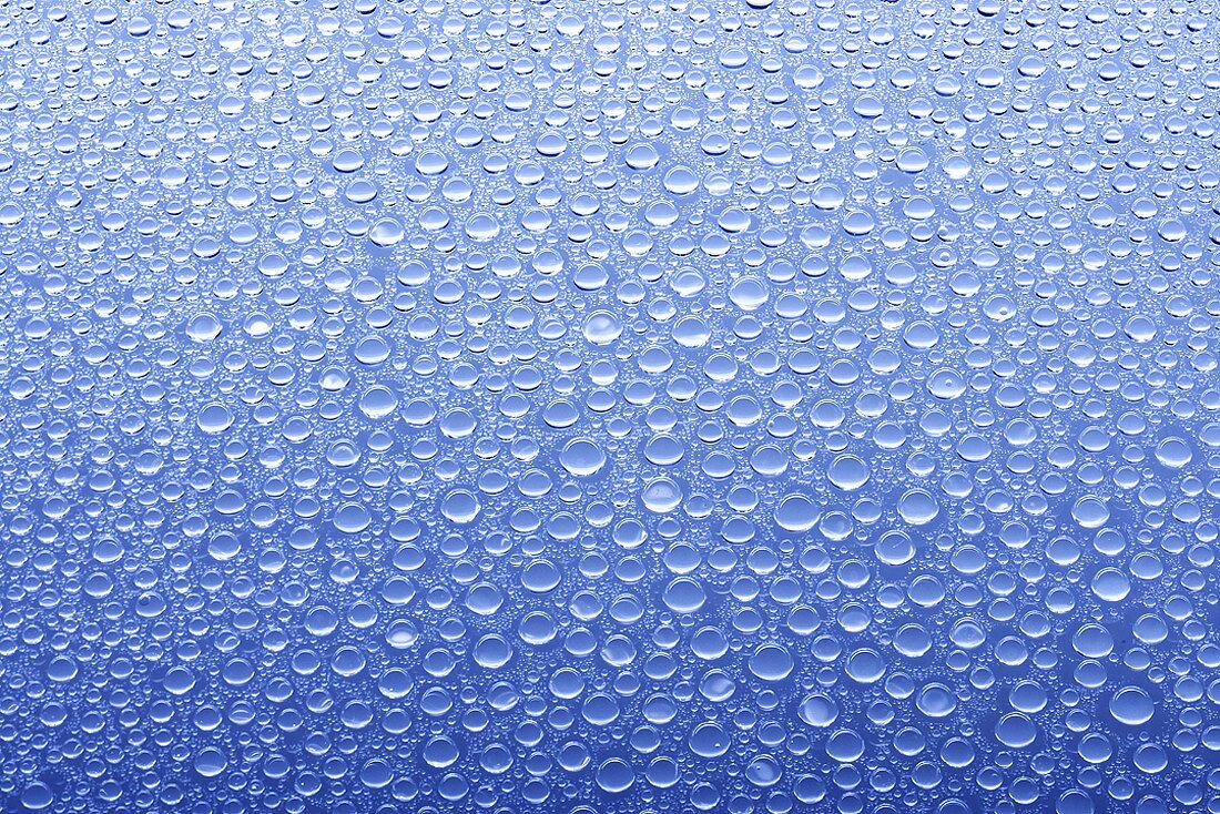 Wassertropfen auf Glasscheibe mit blauem Hintergrund